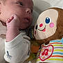 baby, child, closeup, colorful, comfort, cute, expression, face, hand, heart_symbol, indoors, infant, lying_down, monkey_toy, music_note, plush_toy, sleepwear, soft_toy, striped_clothing, toy