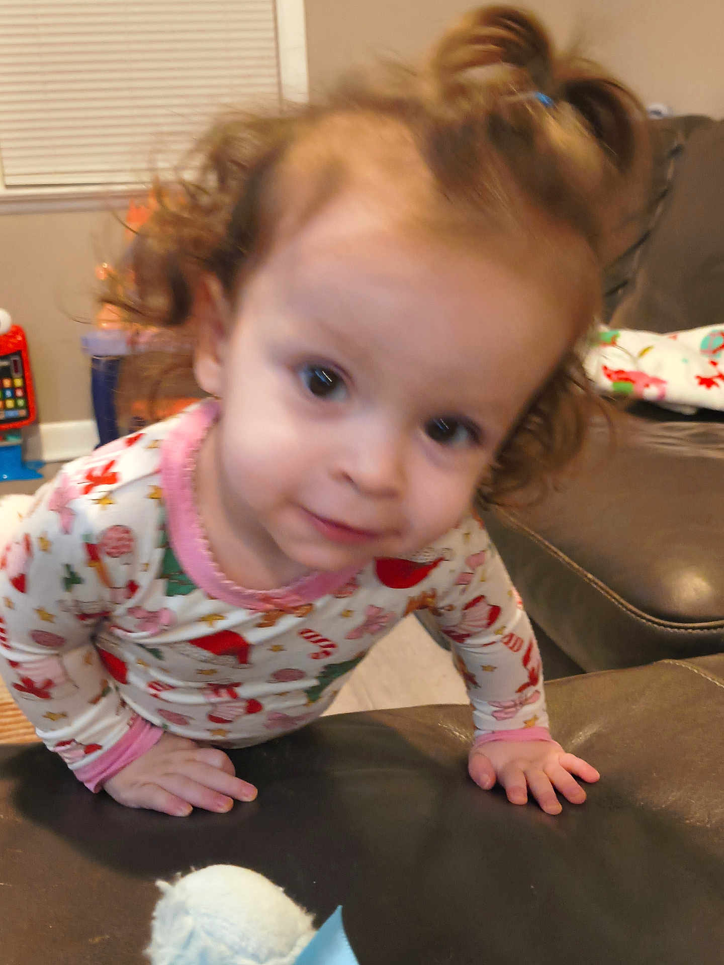 Harper joined the competition — help win amazing prizes! toddler, child, pajamas, indoor, curly_hair, face, couch, toy, hand, window, living_room, smile, person, clothing, furniture, curiosity, home, young_child, baby, portrait