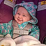 apparel, baby, baby_clothes, blanket, car_seat, child, child_safety, cozy, cute, face, happy, heart_pattern, hooded_jacket, indoor, infant, portrait, safety, seatbelt, smiling, warm
