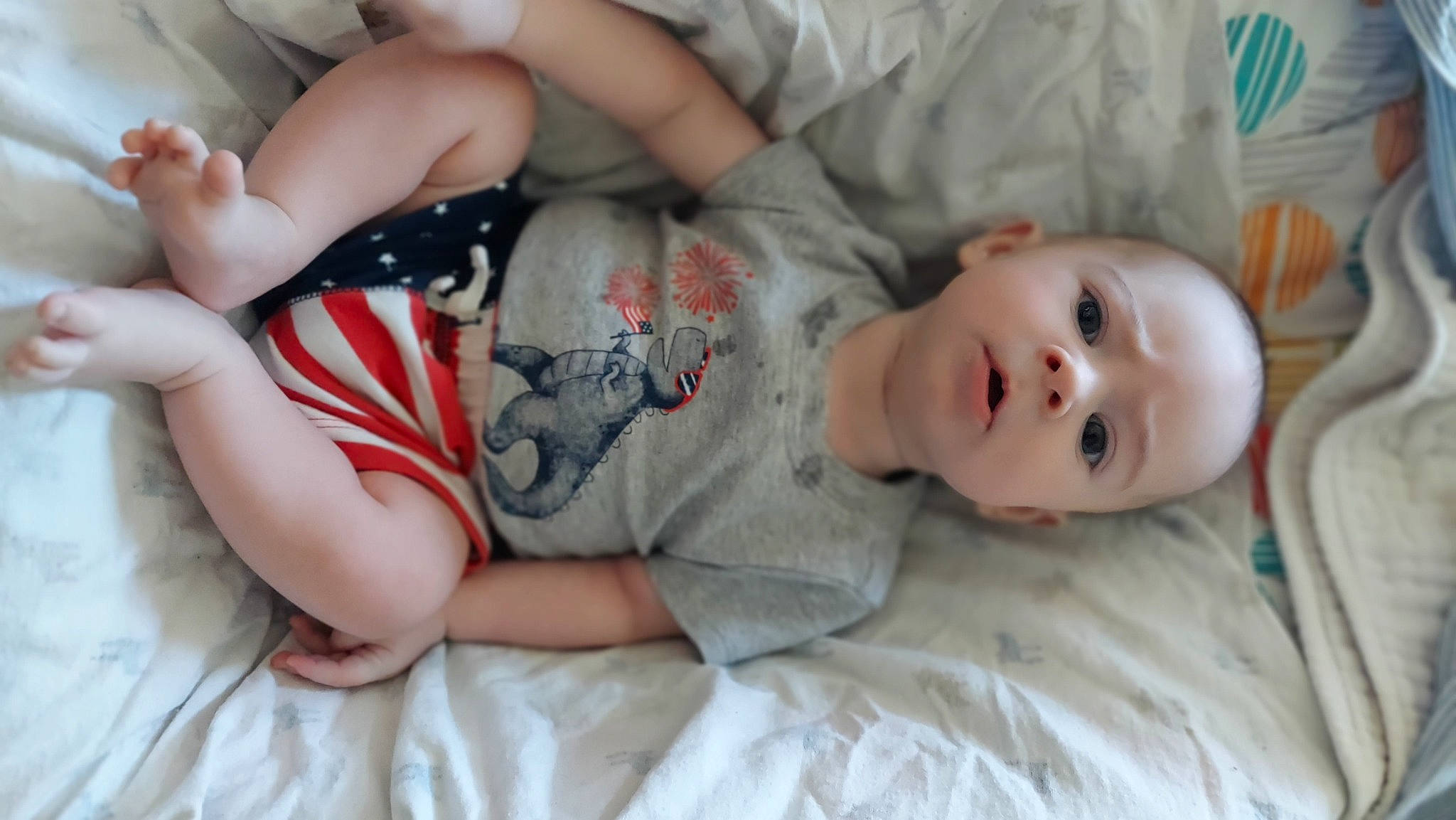 Grayson is registered to the contest to win money with this photo: baby, baby_toddler_clothing, cheek, comfort, couch, elbow, eye, hand, human_body, human_leg, knee, linens, lip, mouth, nose, person, skin, sleeve, thigh, toddler