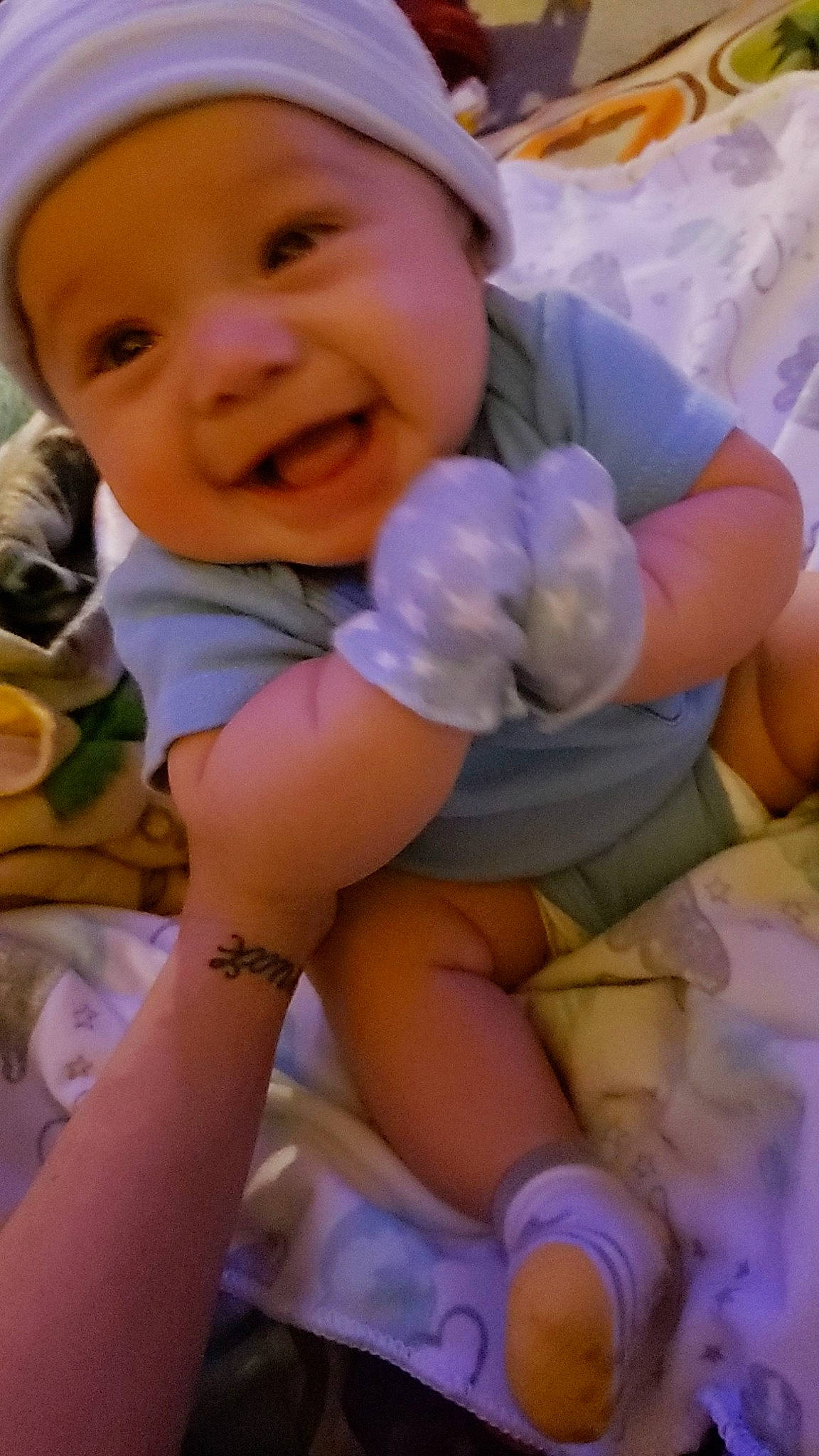 Achilles is registered to the contest to win money with this photo: baby, baby_toddler_clothing, cap, cheek, child, eye, facial_expression, finger, gesture, hand, happy, headgear, headwear, mouth, person, pink, purple, skin, smile, thigh