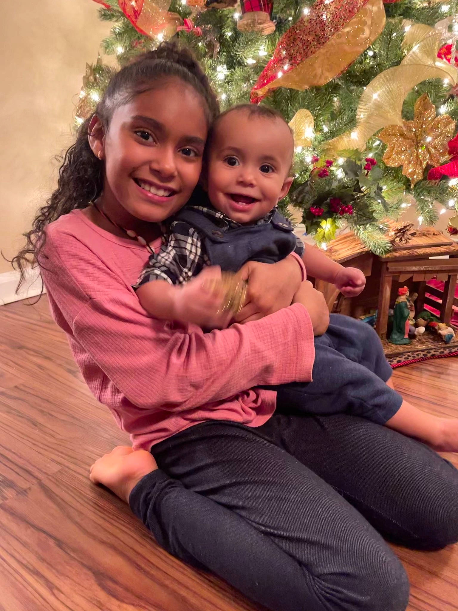 Camilah is registered to the contest to win money with this photo: baby_toddler_clothing, child, christmas, christmas_decoration, christmas_eve, christmas_ornament, christmas_tree, comfort, facial_expression, happy, holiday, holiday_ornament, human, human_body, joy, lap, love, ornament, person, sitting