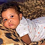Jailani is registered to the contest to win money with this photo: baby, infant, face, eyes, clothing, onesie, polka_dot, blanket, leopard_print, cute, lying_down, skin, earring, portrait, child, young, adorable, expression, indoor, soft