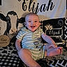 baby, blanket, child, cow_pattern, cute, decor, fabric, face, five_months_sign, foot, happy, head, indoor, infant, name_text, person, portrait, sitting, smiling, striped_clothing