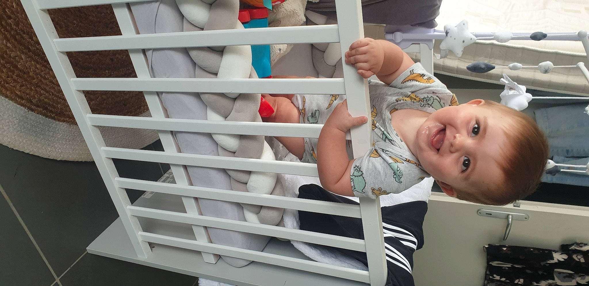 Mylan participe au concours pour gagner de l'argent avec cette photo : baby, baby_safety, baby_toddler_clothing, child, fence, fun, handrail, happy, joy, leisure, person, room, sleeve, smile, t_shirt, thumb, toddler, vacation, white, wood