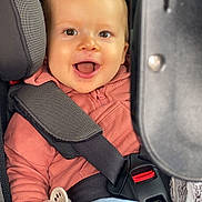 énaël a rejoint le concours — aidez-le/la à gagner de superbes lots ! baby, blue_pants, car_interior, car_seat, child, clothing, cute, happy, indoor, infant, pacifier, person, pink_hoodie, portrait, safety, seat, seatbelt, smiling, transportation, young_child