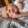 baby, infant, face, hands, blanket, bottle, baby_lotion, close_up, lying_down, pattern, room, soft_light, curious, skin, person, newborn, indoors, expression, resting, pillow