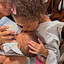 Kai Green is registered to the contest to win money with this photo: child, baby, feeding, bottle, kiss, curly_hair, chair, blanket, toddler, infant, caring, family, indoor, love, tenderness, hand, clothing, person, close_up, cute