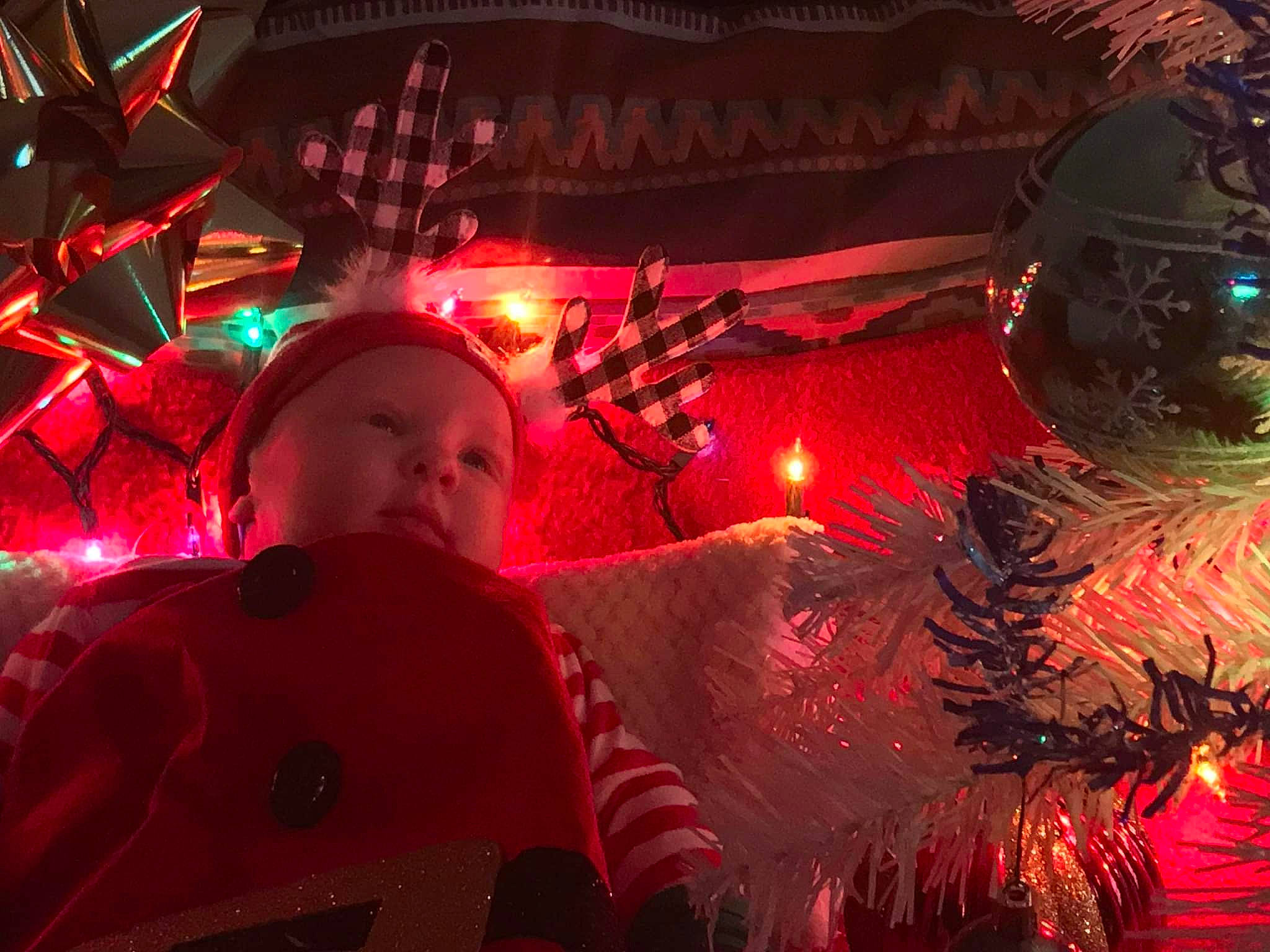 Kashton is registered to the contest to win money with this photo: christmas, christmas_decoration, christmas_eve, christmas_ornament, christmas_tree, darkness, event, evergreen, fun, happy, headwear, holiday, holiday_ornament, light, ornament, person, plant, red, smile, space