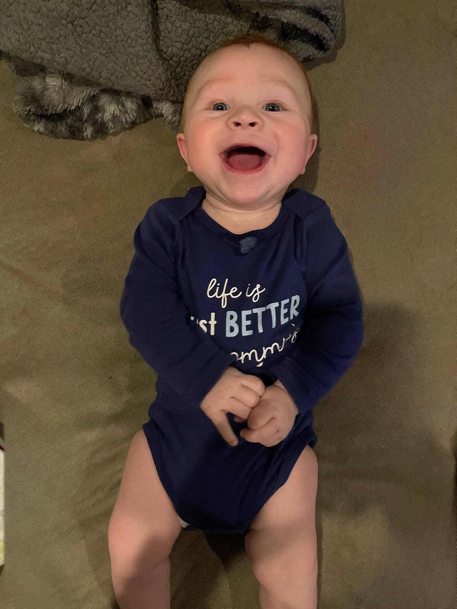 Blake is registered to the contest to win money with this photo: baby, baby_toddler_clothing, cheek, child, chin, eye, face, facial_expression, happy, head, infant_bodysuit, iris, knee, person, skin, sleeve, smile, sportswear, t_shirt, thigh