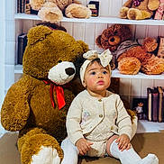 Valentina joined the competition — help win amazing prizes! baby, child, teddy_bear, stuffed_animal, sitting, headband, white_socks, knitwear, toy, shelf, books, indoor, cute, portrait, childhood, soft_toy, floor, curly_hair, red_ribbon, decor