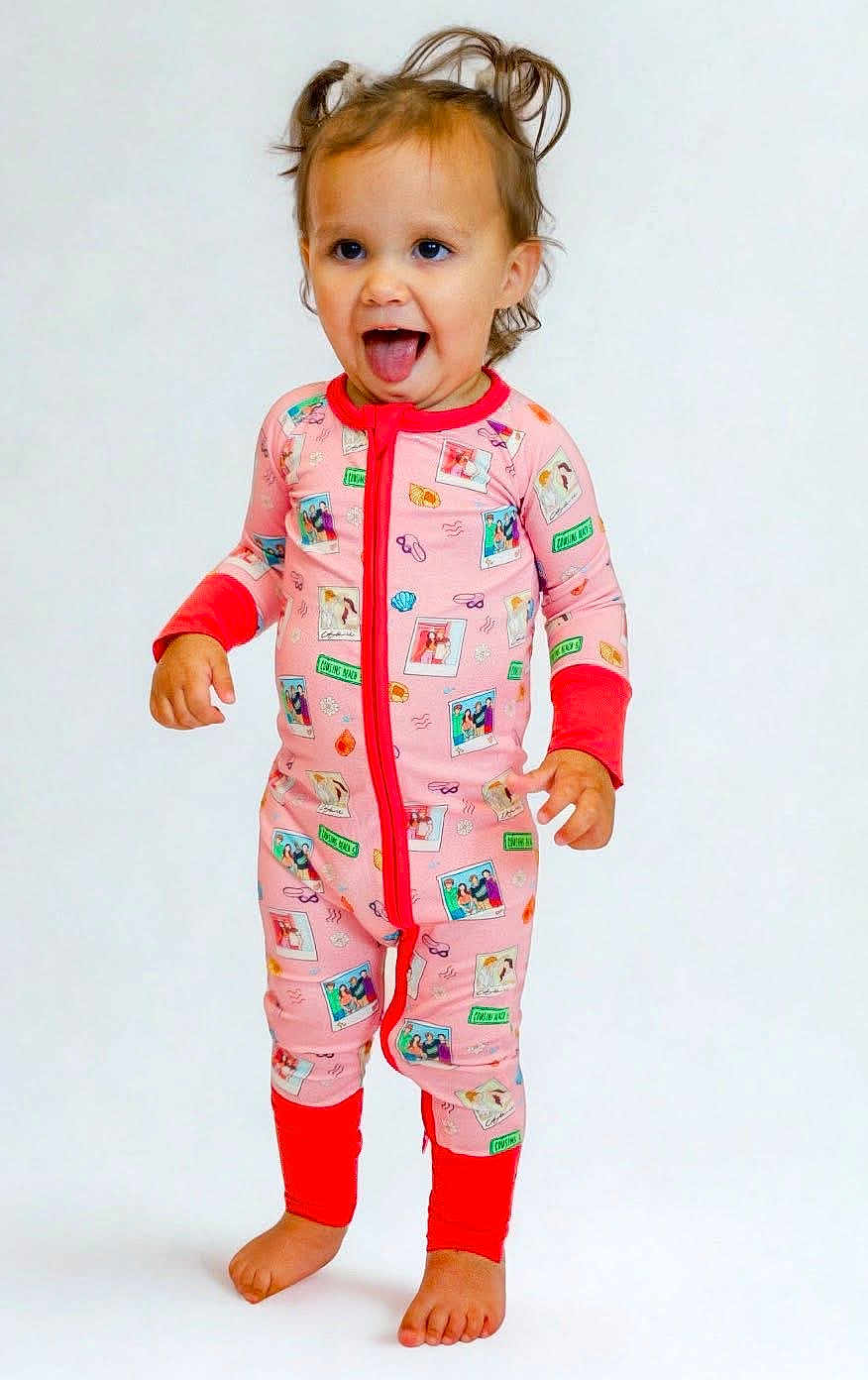 Miley is registered to the contest to win money with this photo: toddler, child, pajamas, standing, barefoot, playful, tongue_out, smiling, indoor, cute, happy, person, clothing, foot, hair, portrait, full_body, baby, fun, studio