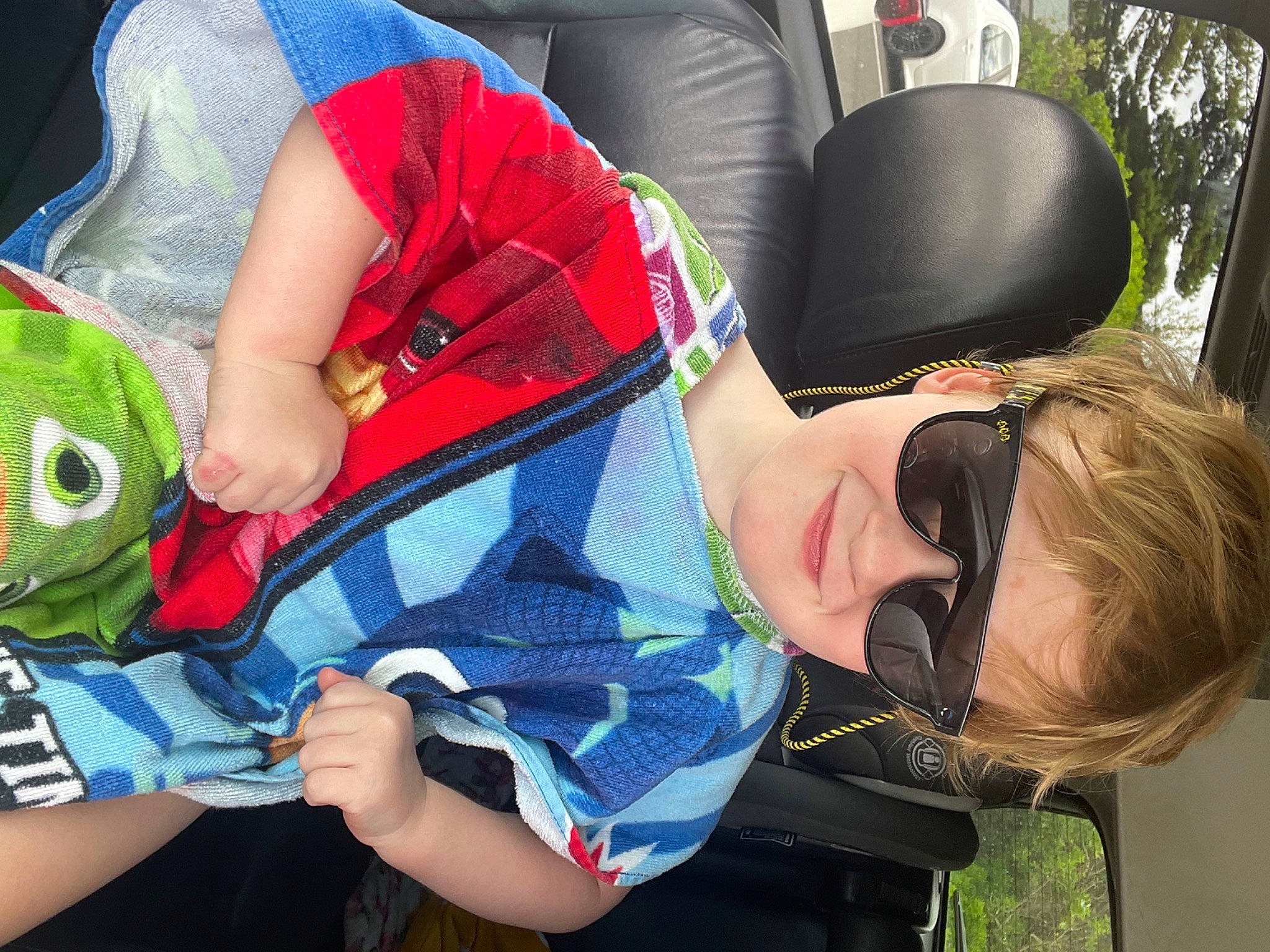 Otto is registered to the contest to win money with this photo: arm, baby_products, child, comfort, event, eyewear, fun, goggles, grass, hat, interaction, joint, joy, lap, leisure, people, person, sitting, sunglasses, t_shirt