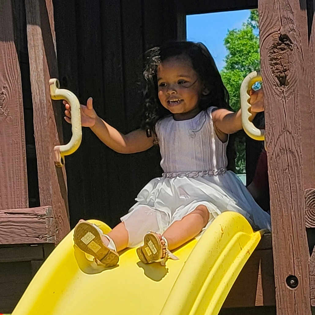 Carol joined the competition — help win amazing prizes! child, clothing, curlyhair, face, female, footwear, girl, hair, head, person, play, shoe, sitting, sleeve, sliding