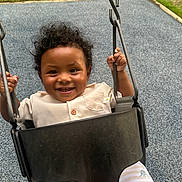 Maximo is registered to the contest to win money with this photo: toddler, child, swing, playground, smiling, curly_hair, outdoor, grass, metal_chain, clothing, shorts, seat, happy, baby, person, play, fun, summer, park, cute