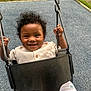 toddler, child, swing, playground, smiling, curly_hair, outdoor, grass, metal_chain, clothing, shorts, seat, happy, baby, person, play, fun, summer, park, cute