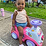 toddler, child, toy_car, outdoor, grass, sidewalk, pigtails, sneakers, shorts, tank_top, picnic_table, people, summer, play, park, happy, cute, bracelet, earrings, daylight