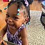 toddler, girl, smiling, laughing, braided_hair, hair_bows, beads, purple_dress, earrings, bracelet, indoor, carpet, wooden_floor, furniture, happy, cute, child, person, portrait, playful