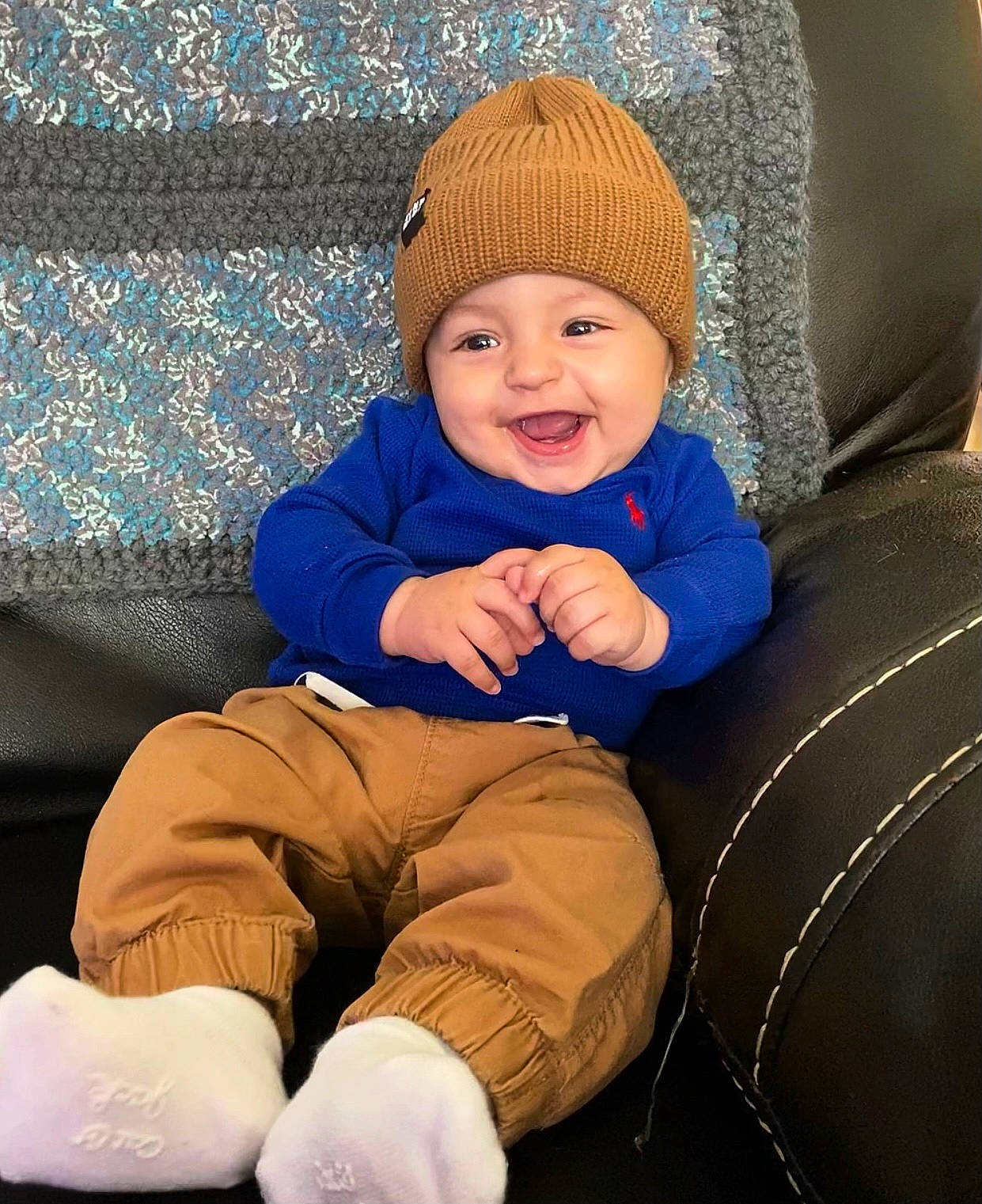 Amani is registered to the contest to win money with this photo: baby, baby_toddler_clothing, cap, child, comfort, couch, electric_blue, eye, face, happy, hat, headgear, headwear, joy, knit_cap, lap, outerwear, person, product, skin