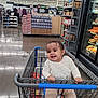 Alayna is registered to the contest to win money with this photo: baby, shopping_cart, supermarket, grocery_store, child, smile, happy, aisle, food, packaging, clothing, floor, retail, store, produce, cart, cute, indoor, person, shopping