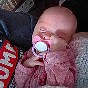 Elizabeth is registered to the contest to win money with this photo: baby, infant, sleeping, pacifier, pink_pacifier, blanket, knit_blanket, cardigan, hand, closed_eyes, face, newborn, cozy, indoor, parent_arm, clothing, portrait, resting, peaceful, snuggling