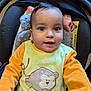 Yusuf a rejoint le concours — aidez-le/la à gagner de superbes lots ! baby, child, infant, car_seat, yellow_clothing, orange_clothing, monkey_applique, face, eyes, hair, smile, indoor, seat, fabric, soft_toy, cute, portrait, person, young_child, apparel