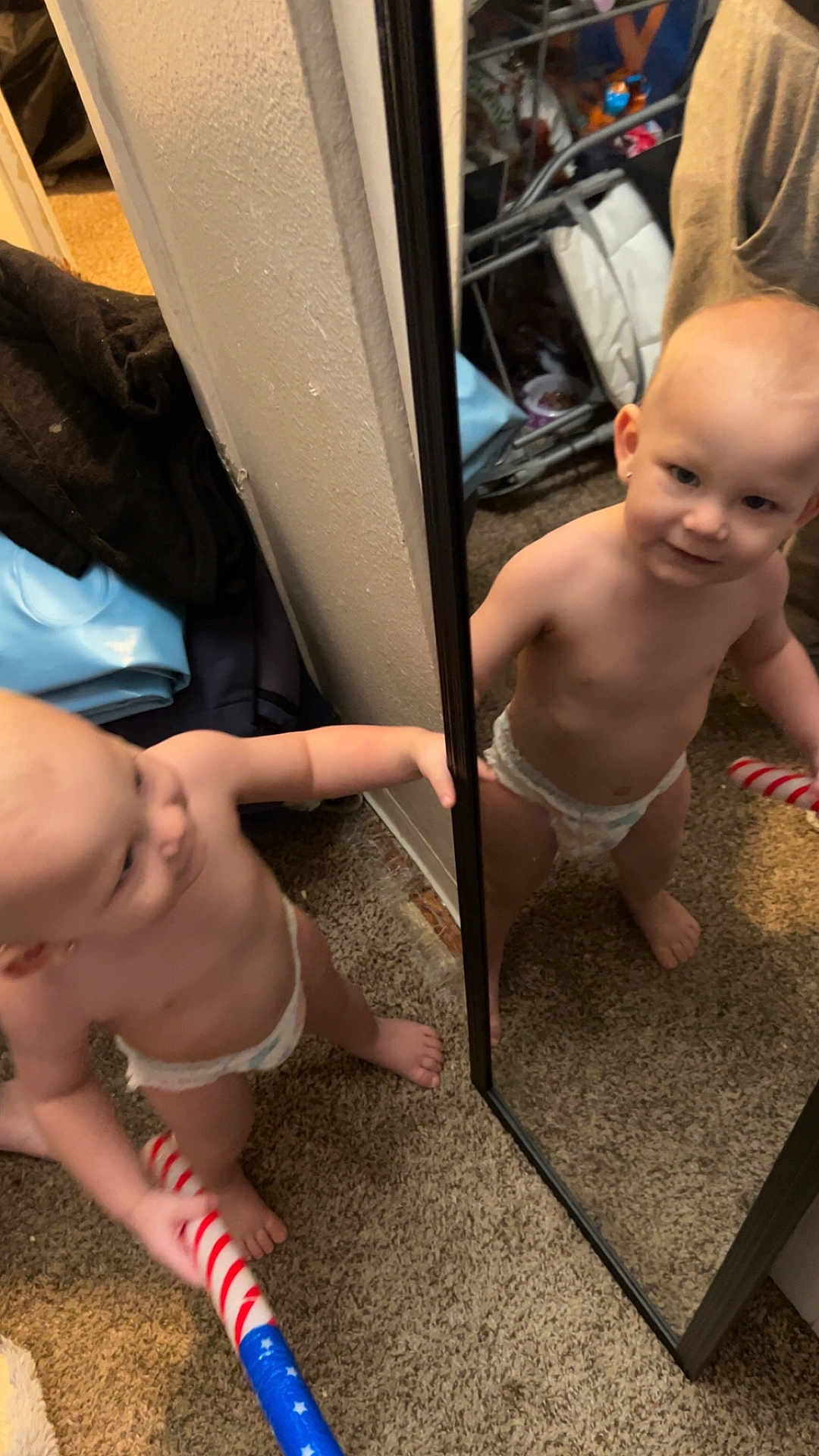 Aostin joined the competition — help win amazing prizes! barefoot, carpet, child, curious, diaper, face, foot, hand, holding, household, indoor, mirror, patriotic, person, red_white_blue, reflection, room, standing, toddler, toy