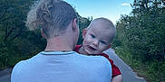 Aostin is registered to the contest to win money with this photo: baby, child, clothing, daytime, earrings, forest, greenery, hair, happy, holding, nature, necklace, outdoor, path, person, road, shoulders, sky, smile, trees
