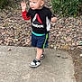 Aostin is registered to the contest to win money with this photo: bushes, car, casual, child, daytime, earrings, expression, fence, gravel, nature, outdoor, person, playing, rock, shorts, sidewalk, sneakers, sweatshirt, toddler, walking