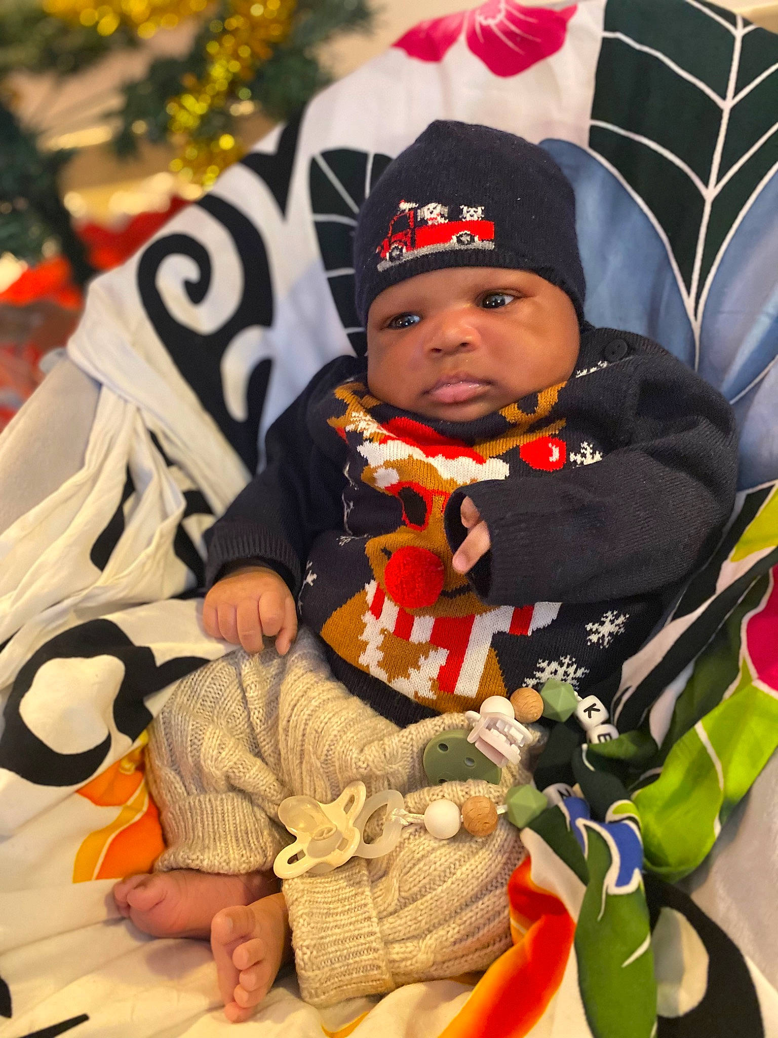 Kënan a rejoint le concours — aidez-le/la à gagner de superbes lots ! baby, baby_products, baby_toddler_clothing, beanie, cap, child, comfort, event, fun, happy, headwear, knit_cap, lap, person, sitting, toddler