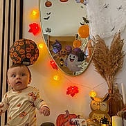 Jules a rejoint le concours — aidez-le/la à gagner de superbes lots ! baby, balloons, child, curious, decorations, fall, festive, ghost, halloween, indoor, lantern, leaves, mirror, mushrooms, orange, owl, pajamas, pumpkin, string_lights, table