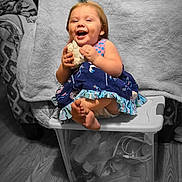 Gracelyn joined the competition — help win amazing prizes! toddler, child, laughing, holding_object, sitting, plastic_container, indoor, floor, wooden_floor, dress, color_pop, blanket, fan, toy, happy, cute, foot, smiling, person, home