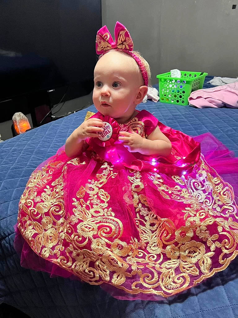 Mamie is registered to the contest to win money with this photo: baby, child, crown, doll, embellishment, event, fashion_accessory, fashion_design, fun, hair_accessory, happy, headpiece, hoopskirt, magenta, pattern, peach, person, pink, purple, surprise