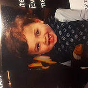 Keaton is registered to the contest to win money with this photo: child, smiling, curly_hair, portrait, face, teeth, magazine_page, printed_photo, glare, reflection, stuffed_toy, clothing, indoor, closeup, paper, eyes, head, young_child, happy, photograph