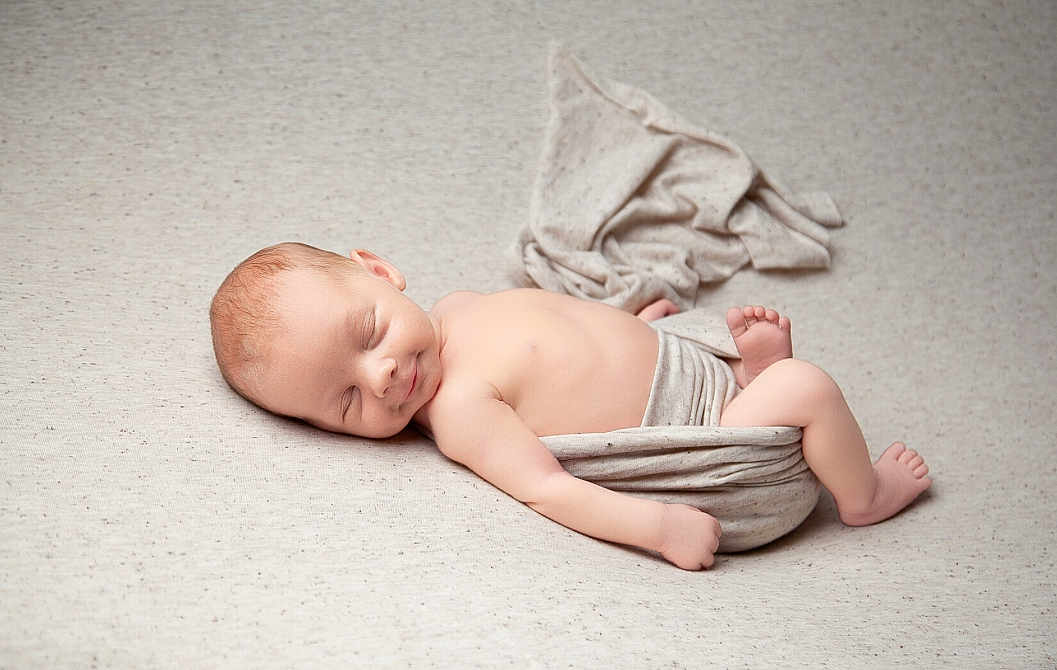 Nathaniel is registered to the contest to win money with this photo: baby, newborn, sleeping, infant, wrapped, blanket, soft_texture, peaceful, skin, head, face, lying_down, cute, rest, toddler, bare_skin, indoors, cozy, calm, portrait