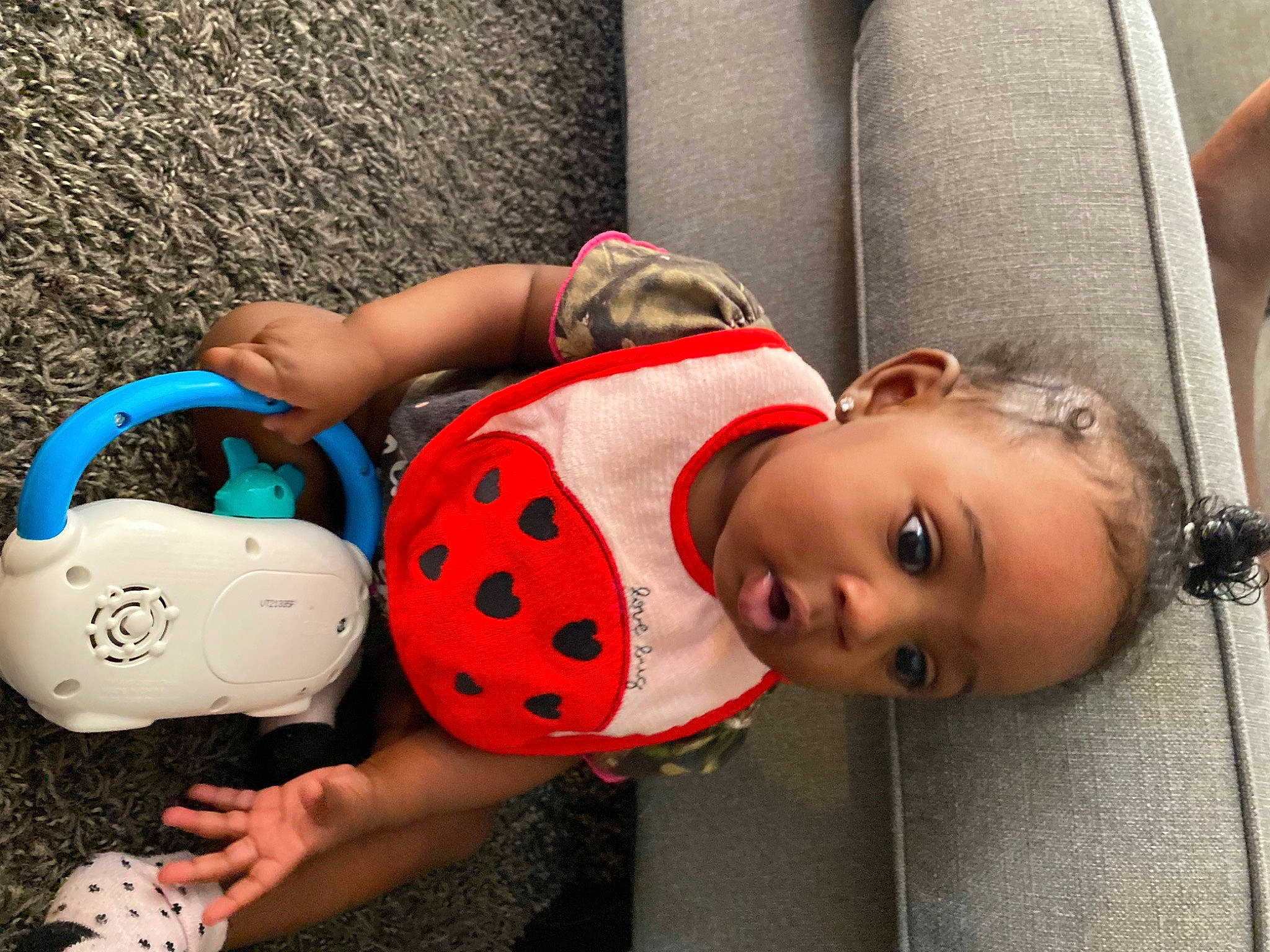 Kahlani is registered to the contest to win money with this photo: baby_toddler_clothing, bag, carmine, child, comfort, fashion, fashion_accessory, fun, happy, headgear, human_leg, joint, pattern, person, red, sitting, textile, thigh, toddler, toy