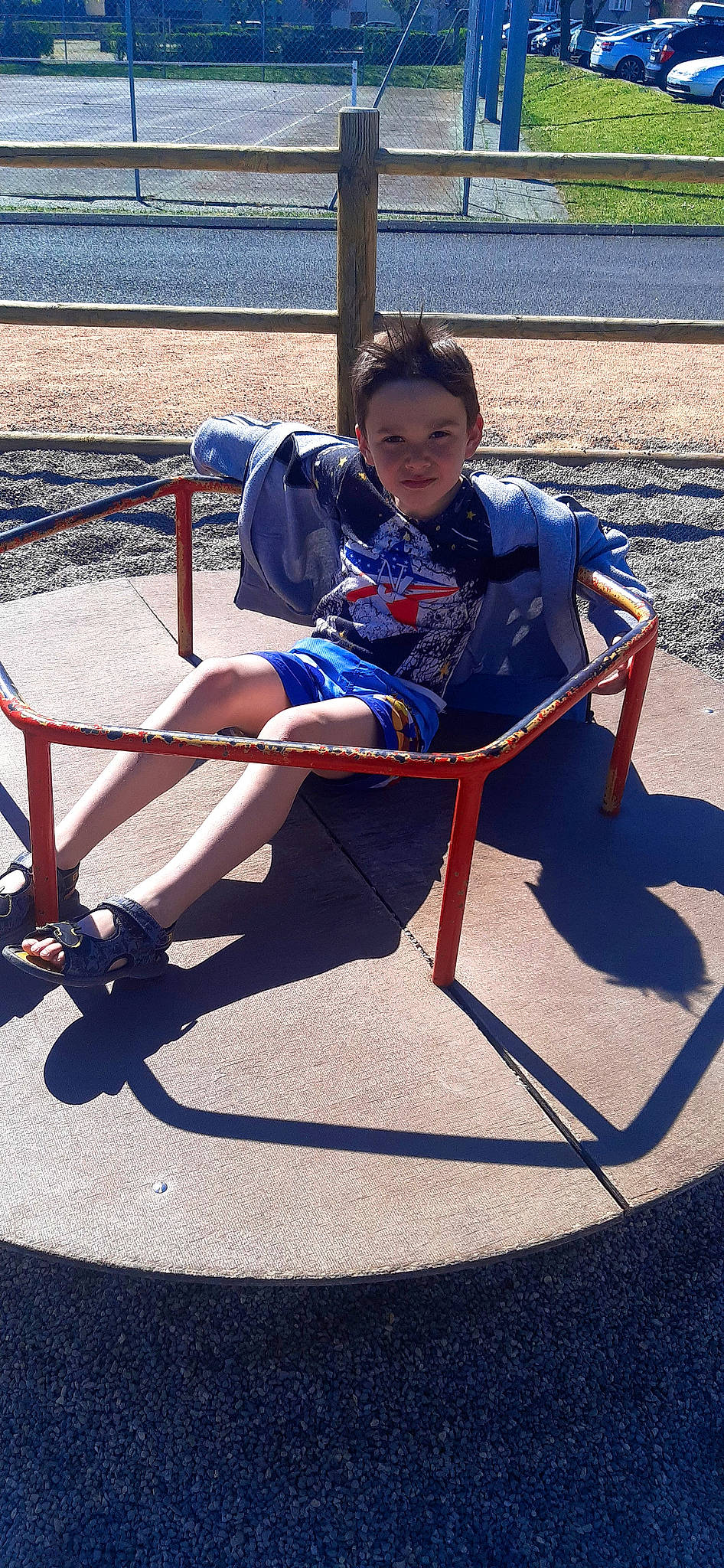 Bryan participe au concours pour gagner de l'argent avec cette photo : baby_toddler_clothing, blue, chair, child, city, concrete, electric_blue, fence, fun, leisure, outdoor_furniture, outdoor_play_equipment, person, play, recreation, shade, shorts, sitting, t_shirt, toddler