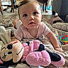 baby, plush_toy, minnie_mouse, blanket, dog, labrador, wooden_chair, floor, indoor, child, toy, couch, person, face, curious, home, carpet, smiling, furniture, toddler