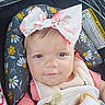 baby, child, infant, bow, headband, blanket, car_seat, daisy_pattern, pink_clothing, face, eyes, cute, portrait, young_child, baby_bib, soft_toys, indoor, closeup, smile, expression