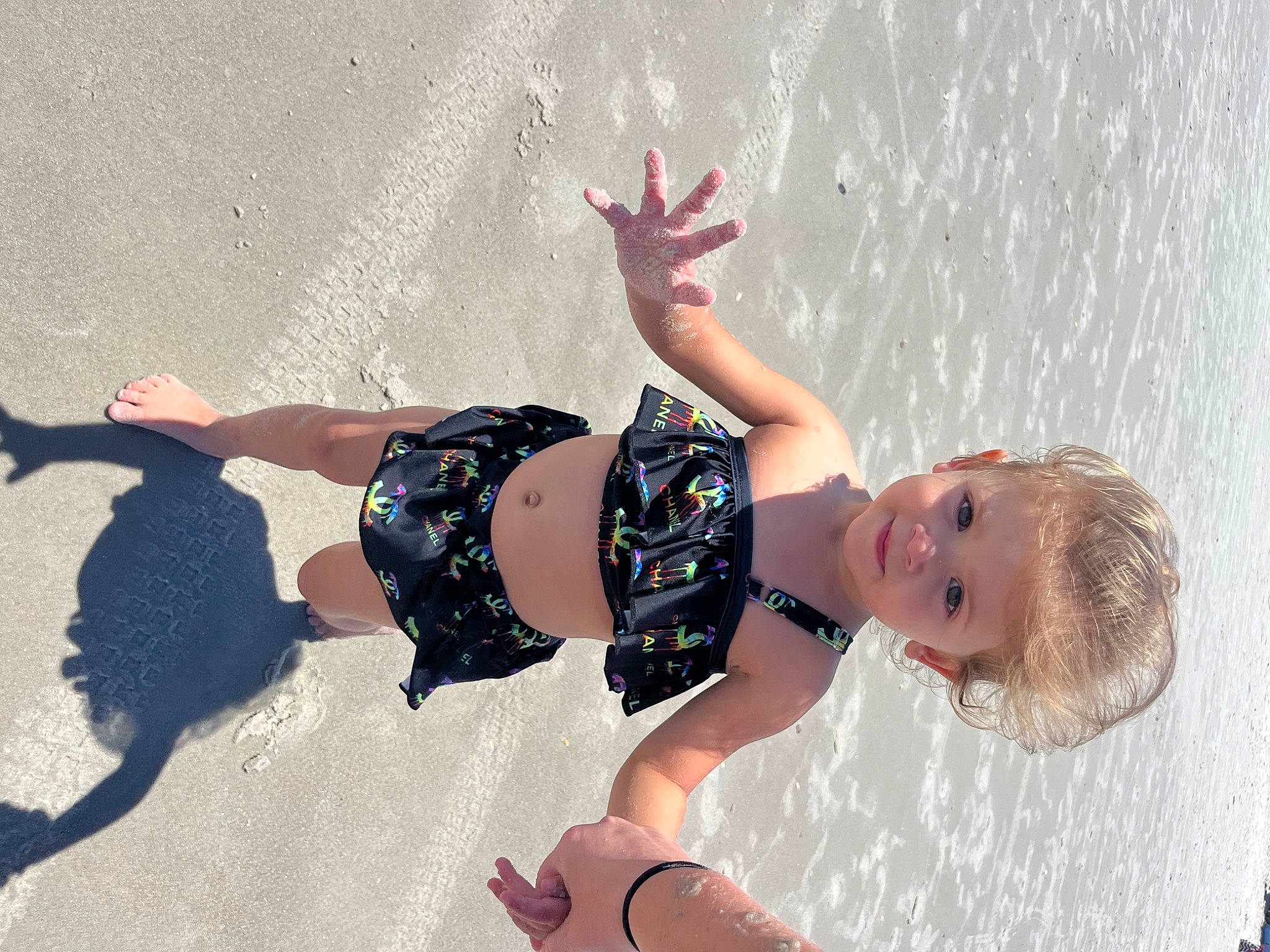 Everleigh is registered to the contest to win money with this photo: baby, barefoot, beach, child, flash_photography, fun, happy, human_leg, knee, leisure, pattern, people_in_nature, person, play, recreation, shadow, smile, thigh, toddler, vacation