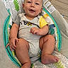 baby, baby_seat, child, comfort, cute, fabric, face, floor, foot, hand, happy, indoor, infant, leaf_pattern, onesie, pattern, sitting, skin, smile, tile_floor