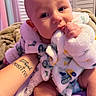 Kyro joined the competition — help win amazing prizes! baby, infant, blanket, tattoo, hand, face, chewing, cozy, soft_texture, indoors, person, child, clothing, comfort, resting, cute, expression, skin, holding, purple_bedspread
