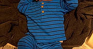 Kyro joined the competition — help win amazing prizes! baby, infant, blue_clothing, striped_outfit, hat, blanket, soft_texture, lying_down, curious_expression, raised_fists, indoor, foot, cozy, warm_lighting, person, child, cute, portrait, young_baby, relaxing