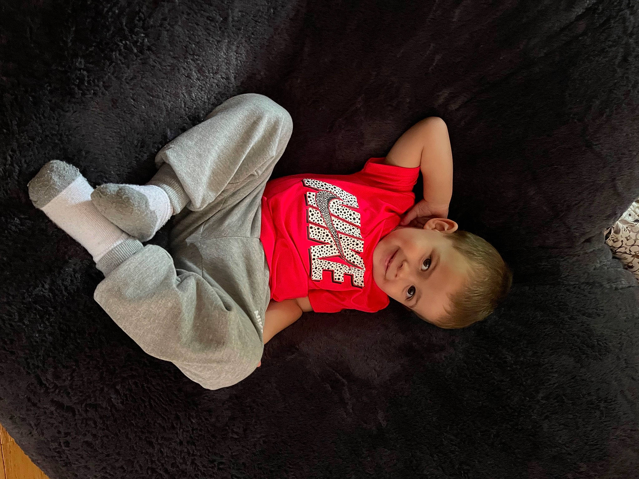 Bentley is registered to the contest to win money with this photo: baby, baby_toddler_clothing, child, comfort, elbow, flash_photography, floor, flooring, human_body, human_leg, joy, knee, linens, person, room, sitting, sleeve, sock, t_shirt, thigh