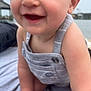 baby, child, smiling, close_up, romper, blue_eyes, skin, arm, hand, outdoor, water, background_blur, happy, infant, cute, person, portrait, clothing, head, face