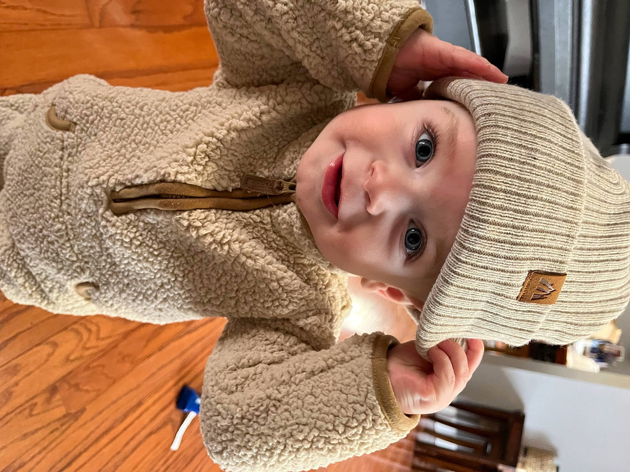 Cam joined the competition — help win amazing prizes! baby_toddler_clothing, cap, child, craft, eye, eyelash, fashion_accessory, flooring, happy, hat, headwear, neck, nose, pattern, person, sleeve, smile, sun_hat, toddler, wood