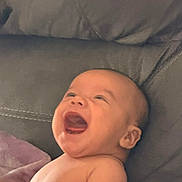 Jordin is registered to the contest to win money with this photo: baby, laughing, smiling, infant, bare_skin, blanket, couch, happy, portrait, child, face, head, expression, indoor, young, cute, joy, relaxing, comfort, seated