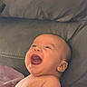 baby, laughing, smiling, infant, bare_skin, blanket, couch, happy, portrait, child, face, head, expression, indoor, young, cute, joy, relaxing, comfort, seated