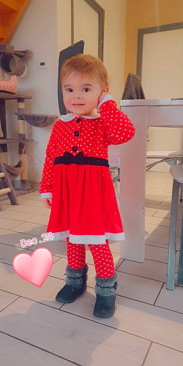 Léna a rejoint le concours — aidez-le/la à gagner de superbes lots ! baby_toddler_clothing, child, dress, face, fashion_design, flooring, knee, magenta, one_piece_garment, orange, pattern, person, pink, red, sleeve, sock, standing, textile, toddler, waist