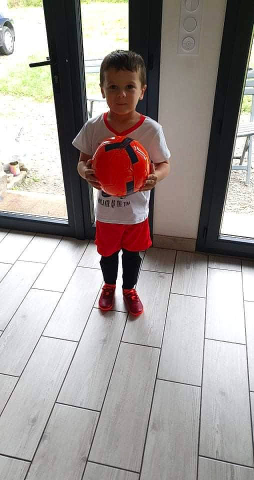 Enzo a rejoint le concours — aidez-le/la à gagner de superbes lots ! boot, child, face, flooring, football, fun, happy, leg, leisure, musical_instrument, person, plucked_string_instruments, recreation, sleeve, sneakers, t_shirt, thigh, tire, toddler, wheel